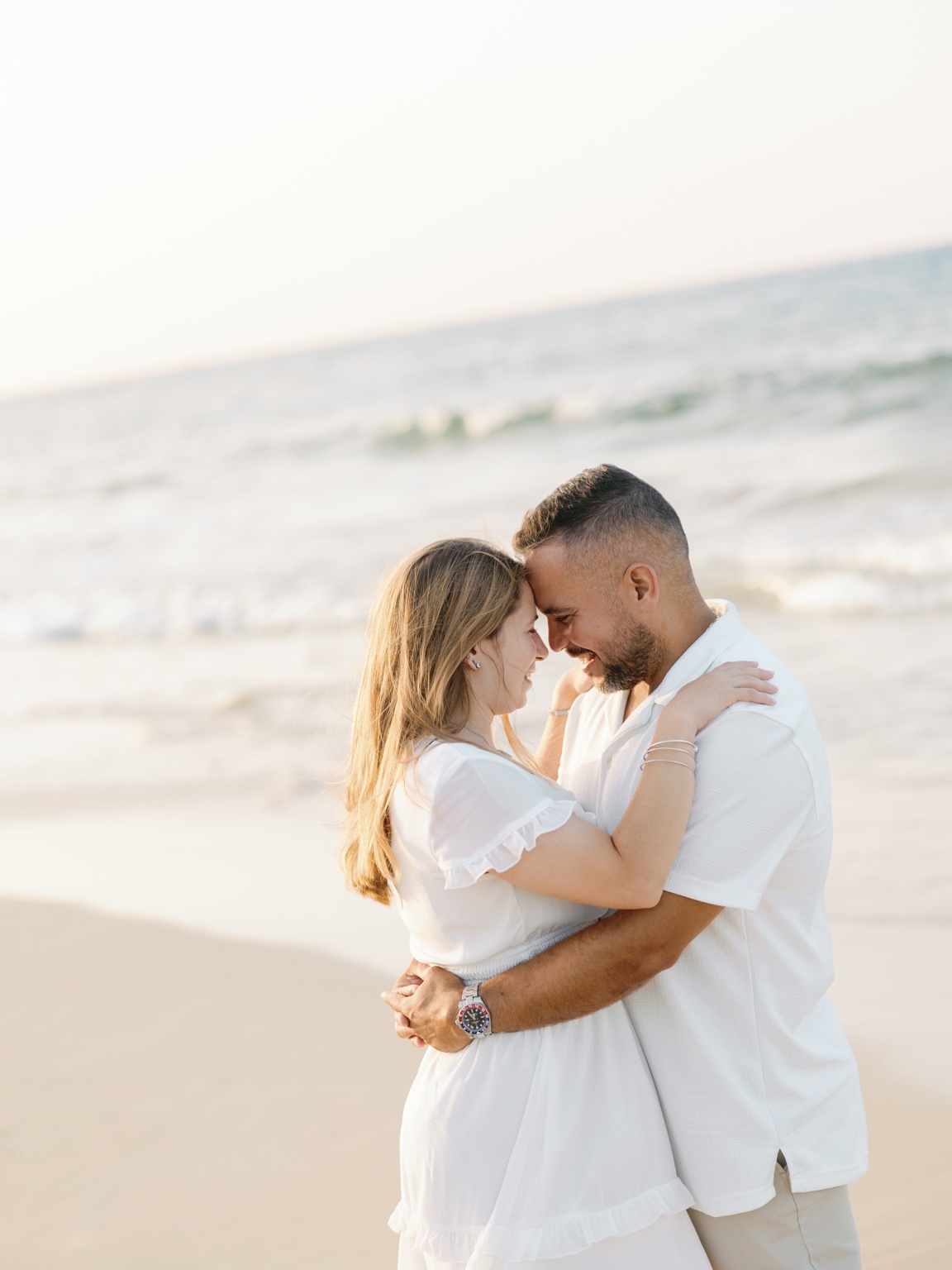 Jori and Greg embracing on the beach