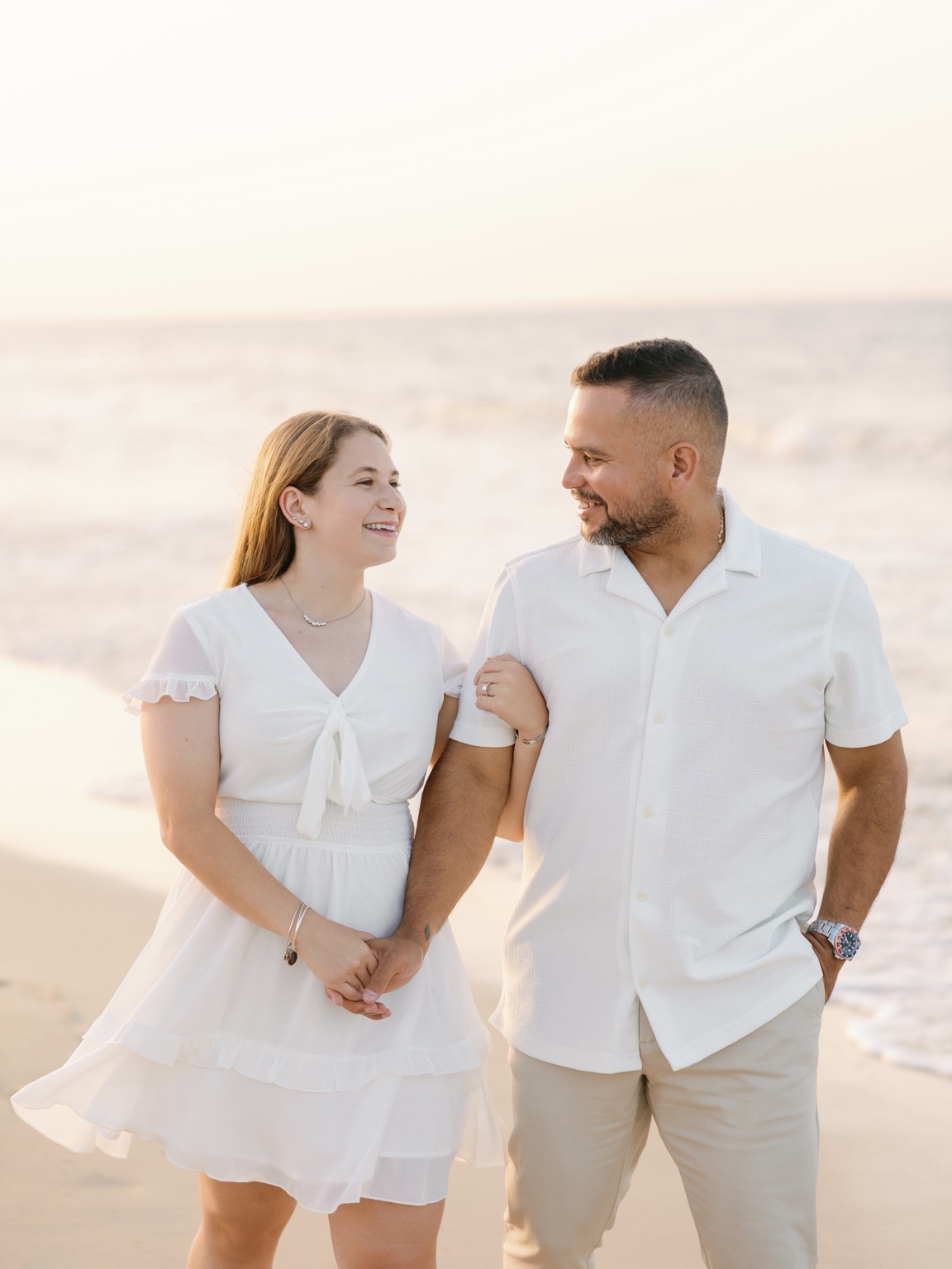 Jori and Greg walking hand in hand on the beach